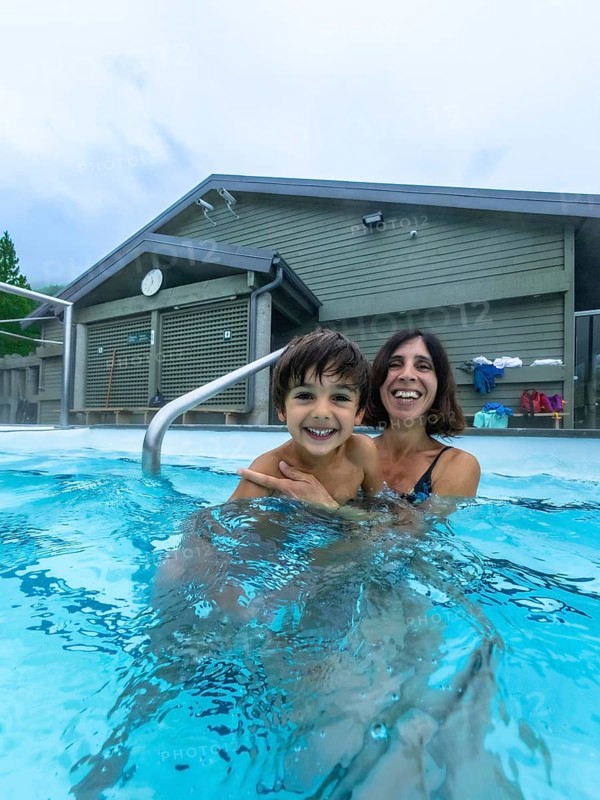 Mother and son are smiling and having fun while bathing in miette hot springs, located in the stunning jasper national park, a renowned destination in the canadian rockies