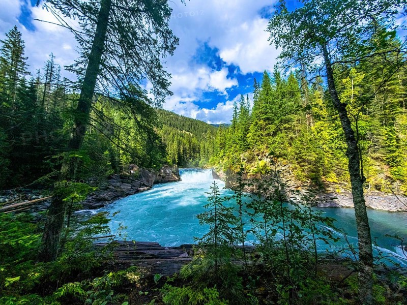 Majestic overlander falls cascading into the vibrant turquoise waters of the fraser river, surrounded by lush green forests in mount robson provincial park, british columbia