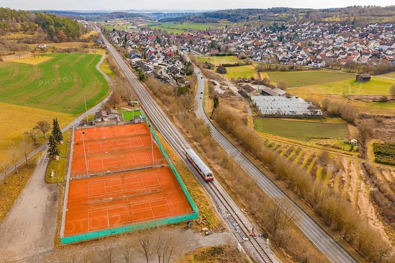 Train line and tennis courts on the outskirts of the city in hilly countryside, historic event, first test run with a passenger train on the Hermann tracks, Hesse railway since 1988, Ostelsheim, Calw district, Germany