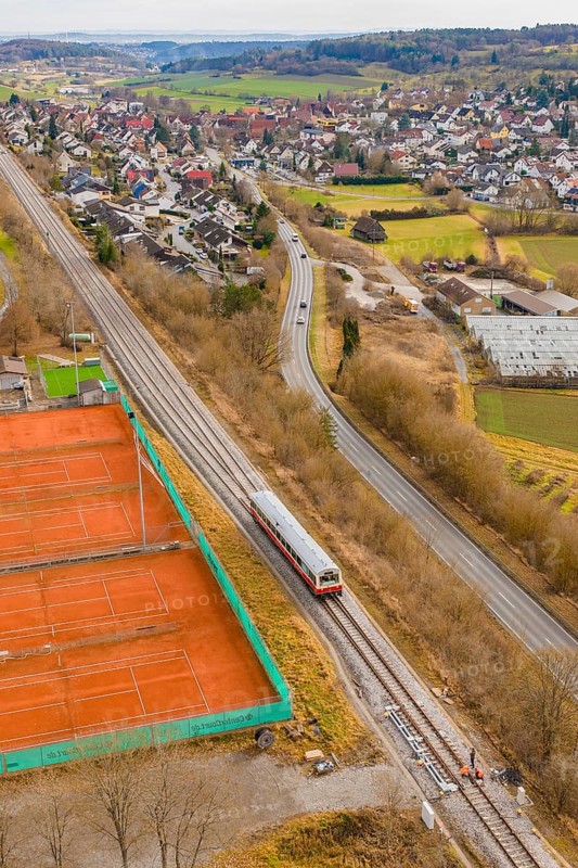Train travels along tennis courts near a city, historic event, first test run with a passenger train on the Hermann tracks, Hesse railway since 1988, Ostelsheim, Calw district, Germany