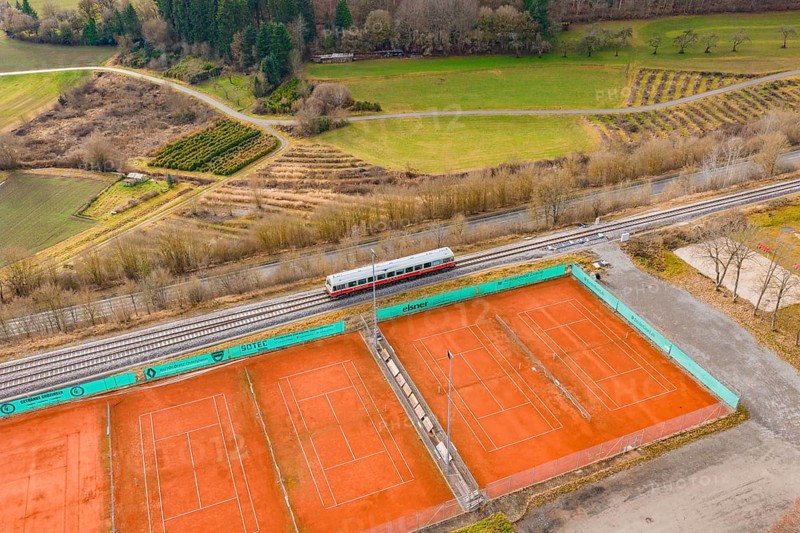 Aerial view of tennis courts next to a train line, historic event, first test run with a passenger train on the Hermann tracks, Hesse Railway since 1988, Ostelsheim, Calw district, Germany
