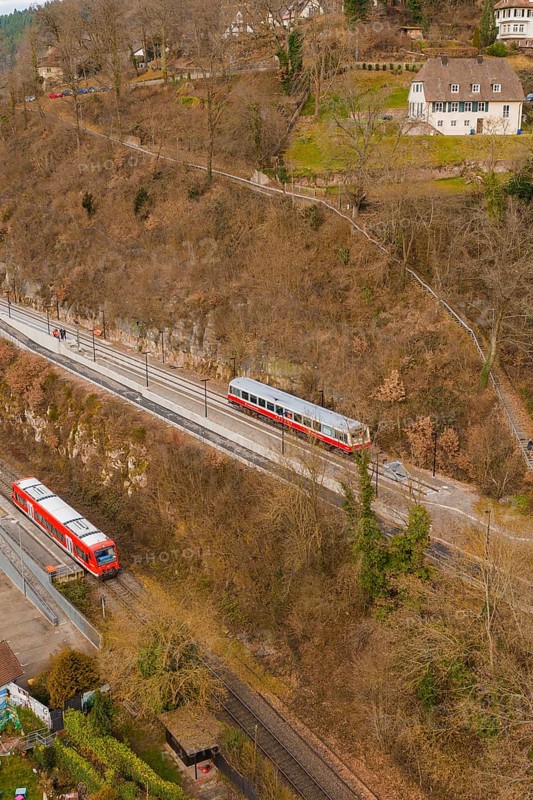 Train on tracks next to wooded hills with buildings in a wintry landscape, historic event, first test run with a passenger train on the Hermann tracks, Hesse Railway since 1988, Calw, Calw district, Germany