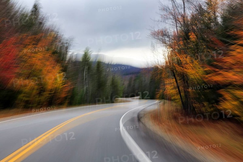 Winding country road through forest, autumn leaves, Indian summer, dark rain clouds, smudge effect, blur, symbolic photo, speed, Kancamagus Highway, White Mountain, New Hampshire, New England, USA