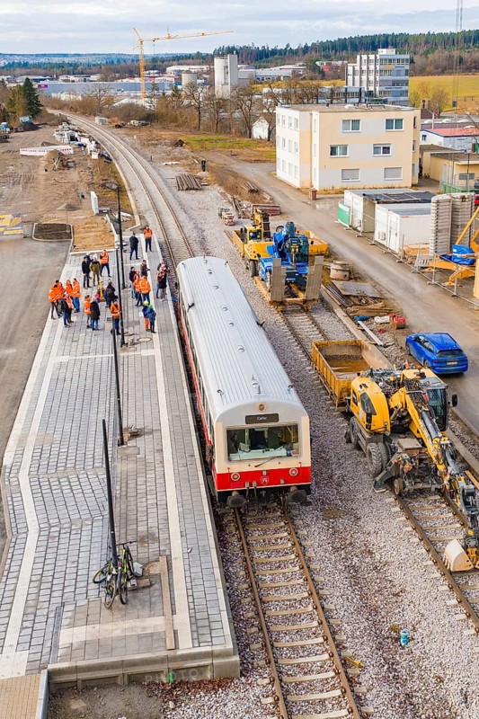 Train stops at a construction site surrounded by workers with industrial buildings in the background, historic event, first test run with a passenger train on the Hermann tracks, Hesse Railway since 1988, Althengstett, Calw district, Germany