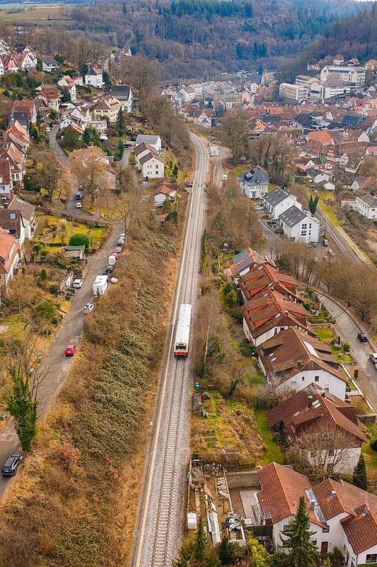 Suburb with railway line through hilly landscape with various residential buildings, historic event, first test run with a passenger train on the Hermann tracks, Hesse Railway since 1988, Calw, Calw district, Germany