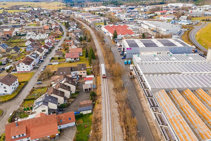 Cityscape with a train traveling through a mix of residential district and industrial area, historic event, first test drive with a passenger train on the Hermann tracks, Hesse Railway since 1988, Althengstett, Calw district, Germany