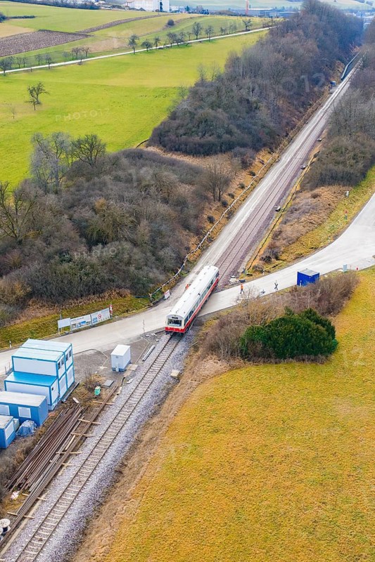 Train travels through a rural landscape with small infrastructures and surrounded by fields, historic event, first test run with a passenger train on the Hermann tracks, Hesse Railway since 1988, Calw district, Germany