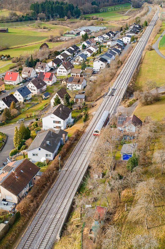 Rural area along railway tracks with houses and trees, historic event, first test run with a passenger train on the Hermann tracks, Hesse Railway since 1988, Ostelsheim, Calw district, Germany