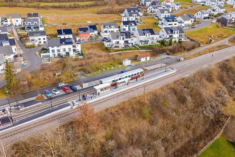 New residential development next to railway tracks in winter surroundings, historic event, first test run with a passenger train on the Hermann tracks, Hesse Railway since 1988, Ostelsheim, Calw district, Germany