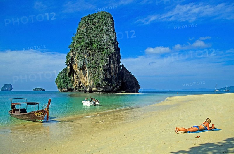 Rocks in the sea, people and longtail boat on Pranang Cave beach, two years in front of the tsunami, Krabi, Thailand, December 2002, vintage, retro, old, historic