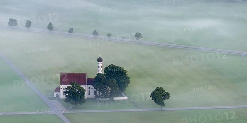 St. Coloman pilgrimage church in front of sunrise in autumn fog, Königswinkel, Ostallgäu, Allgäu, Bavaria, Germany