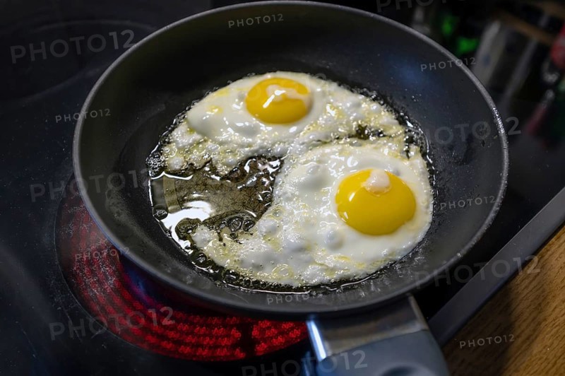 Two fried eggs in a pan on the stove, Bavaria, Germany