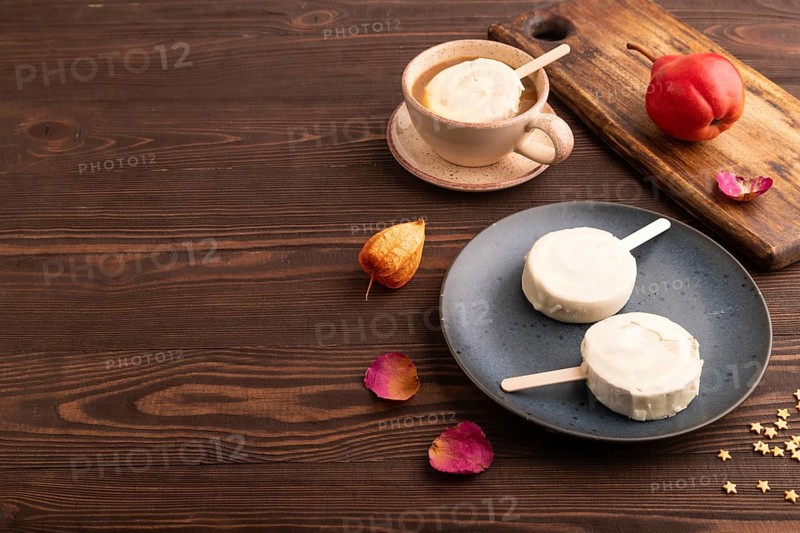 ?hocolate Ice cream in white glaze, cup of coffee, on brown wooden background, side view, copy space