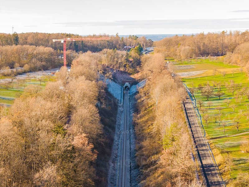 Aerial view of a railway tunnel surrounded by trees and meadows in autumn, construction of the Hermann Hesse Railway, Calw, Germany