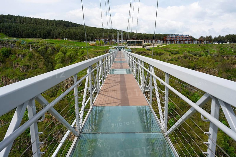 A modern suspension bridge with glass floor over a green landscape with forest, diamond bridge, Diamond Glass Bridge, world's longest free-hanging structure, Dashbashi Gorge, Khrami River, Chrami, Tsalka Nature Reserve, Kartli, Georgia
