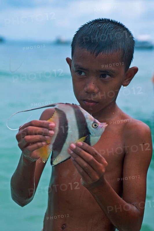 Boy with a tropical fish on Ko Phi Phi Don, two years in front of the tsunami, Thailand, December 2002, vintage, retro, old, historic