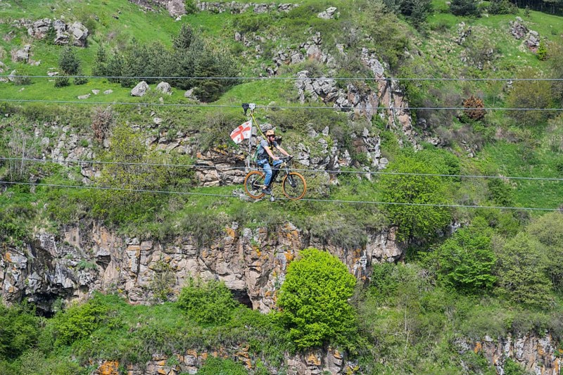A bicycle ride on a rope leads across a rocky, green gorge, Dashbashi Gorge, Khrami River, Tsalka Nature Reserve, Kartli, Georgia