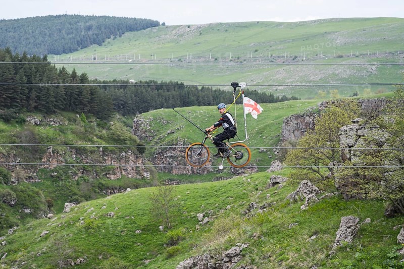 Cycling on a stretched rope across a hilly landscape with trees, Dashbashi Gorge, Khrami River, Tsalka Nature Reserve, Kartli, Georgia