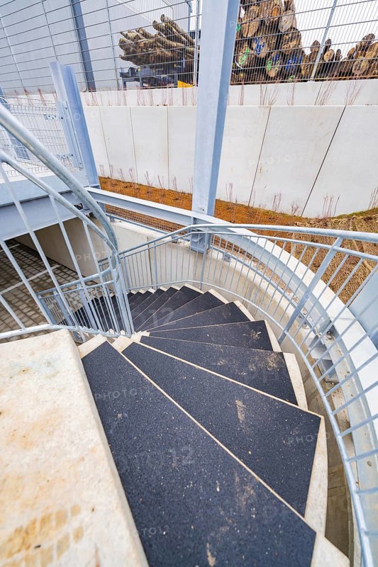 Downward spiral of steel and concrete staircase, showing modern building style, parking garage construction with charging infrastructure, Calw, Germany