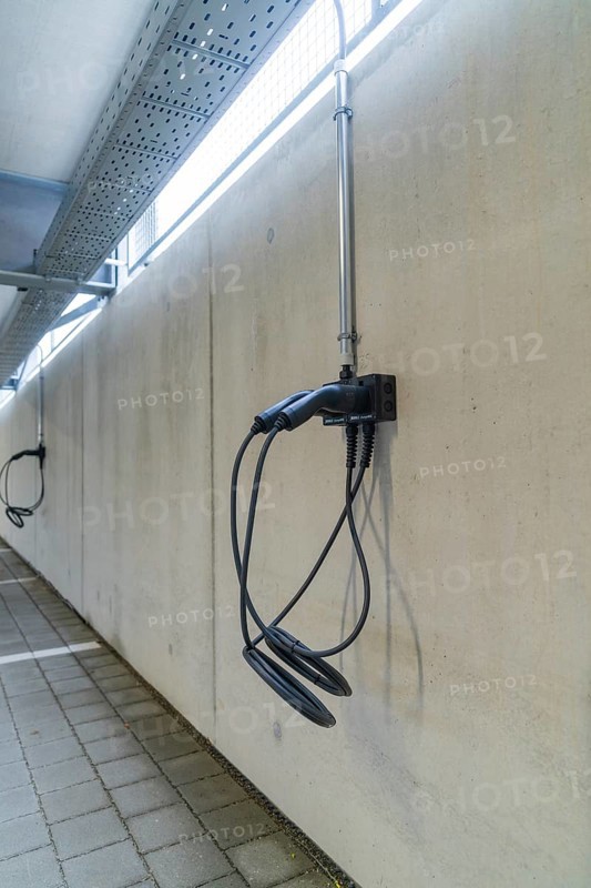 Electric charging station mounted on a concrete wall in a parking garage, parking garage construction with charging infrastructure, Calw, Germany