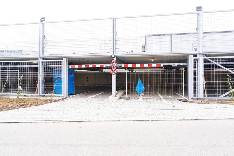 An empty parking deck with a barrier and a traffic sign. The area is secured by fences, car park construction with charging infrastructure, Calw, Germany