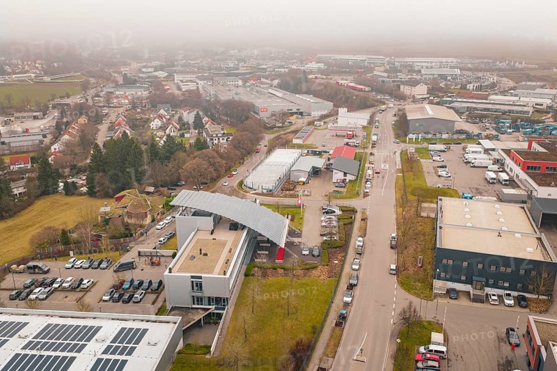 Urban landscape with industrialized areas and buildings in winter, parking garage construction with charging infrastructure, Calw, Germany