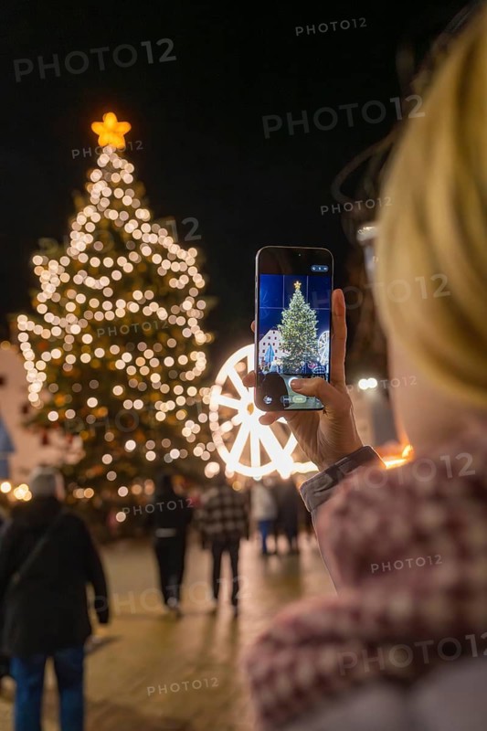 A Christmassy tree is photographed by a person with a mobile phone, Weihnachtsmark Nagold, LandkreisCalw, Germany