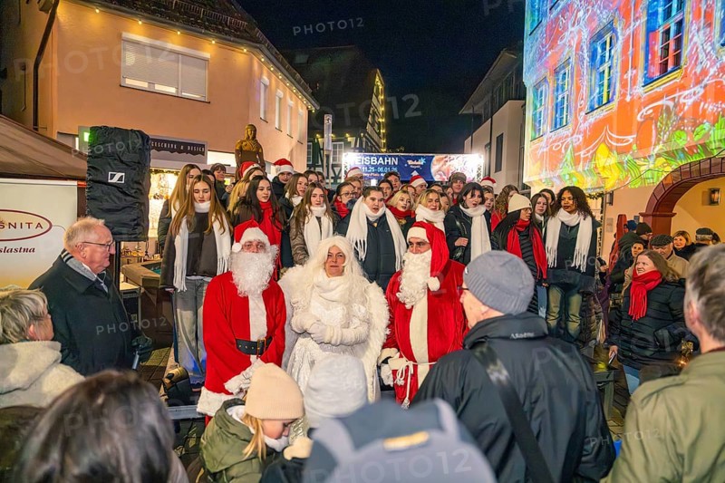 People wearing Christmas costumes at a night outdoor party surrounded by colorful lights, Weihnachtsmark Nagold, LandkreisCalw, Germany
