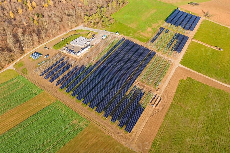 Extensive solar system surrounded by green fields, surrounded by autumn trees, energy revolution, construction of PV open space, Baden-Württemberg, Germany