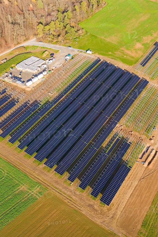 Large solar park right on the edge of an autumn forest and green fields, energy revolution, construction of PV open space, Baden-Württemberg, Germany