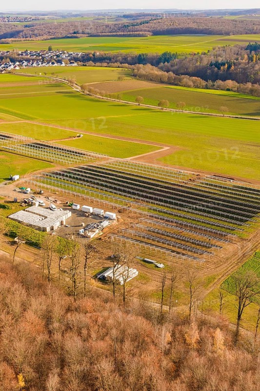 Large solar system next to buildings, surrounded by fields and forests, energy revolution, construction of PV open space, Baden-Württemberg, Germany