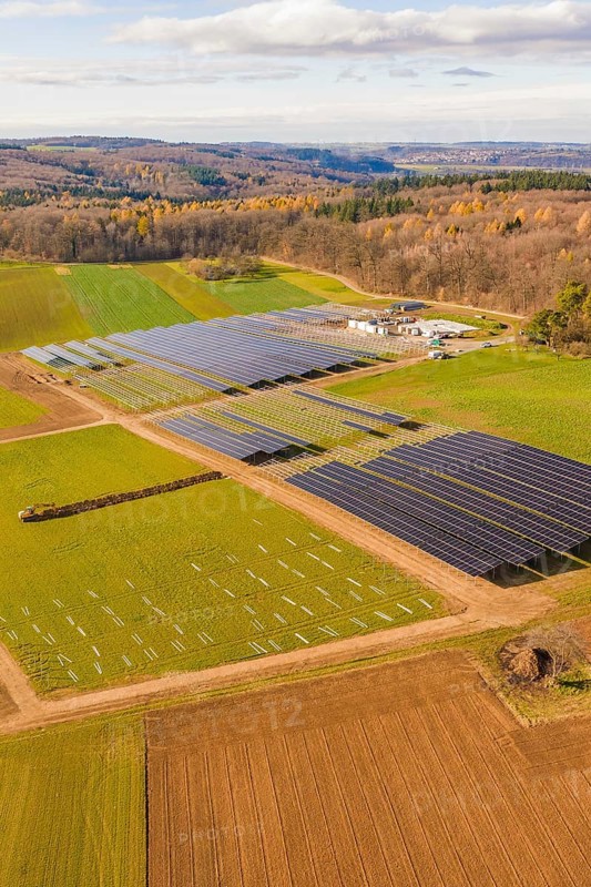Aerial view of a solar park surrounded by fields and autumn forests, energy revolution, construction of PV open space, Baden-Württemberg, Germany