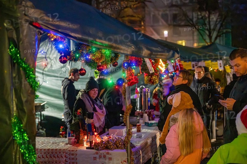 Colourful and festively decorated stands at a Christmas market with many visitors, Christmas market, Aidingen, Germany