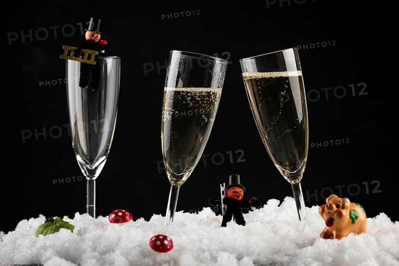 Champagne glasses filled with lucky charms for New Year in the snow