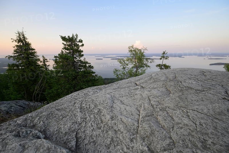 Tranquil view of a lake at dusk with rocks and trees in the foreground, Koliberg, Finland's most famous viewpoint, Ylä-Koli, North Karelia, Finland