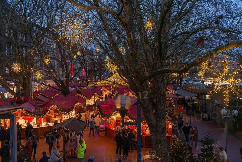 Christmas market on Holstenplatz in Kiel, city center, trees, shops, pedestrian zone, early evening, stalls, visitors, glowing stars, lights, Christmas decorations, fun, festive atmosphere, Christian festival, view from above, Schleswig-Holstein, Germany