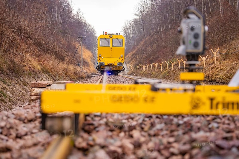 Yellow work machine on railroad track with surveyor in autumn environment, stuffing machine on Hermann, Hesse, railway, Althengstett, Calw district, Germany