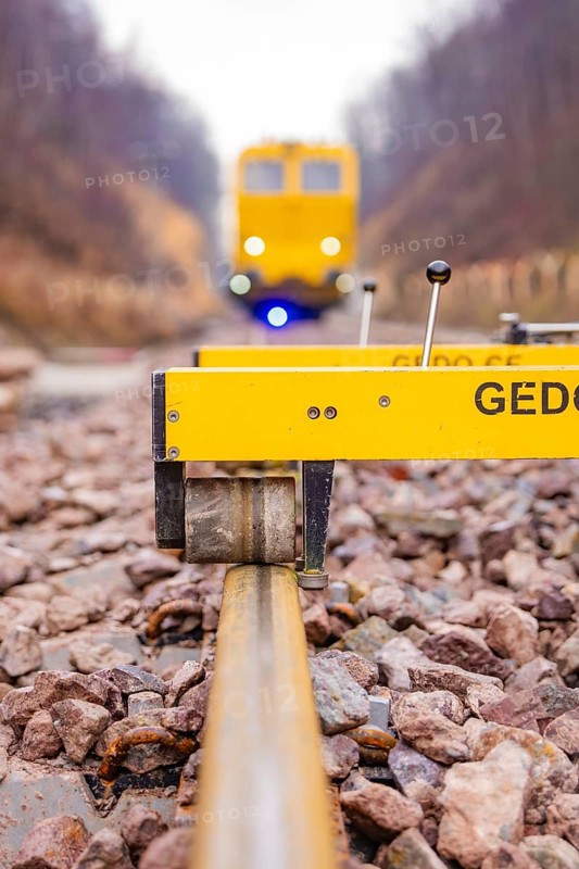 Close-up of a rail surveyor, a yellow vehicle in the background, tamping machine on the Hermann, Hesse, railway, Althengstett, Calw district, Germany