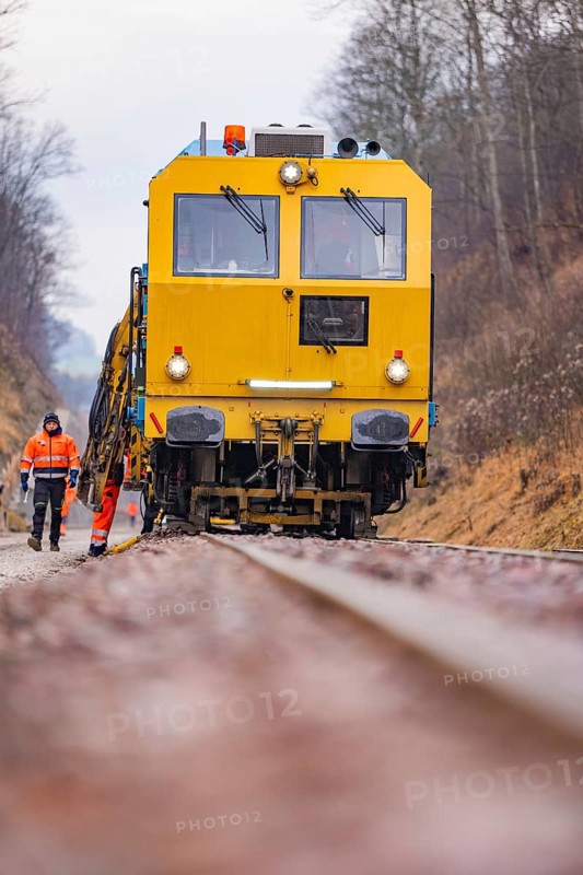 Yellow track construction equipment on rail road, worker watching work, stuffing machine on Hermann, Hesse, railway, Althengstett, Calw district, Germany
