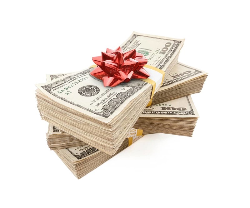 Stacks of one hundred dollar bills with red bow on top