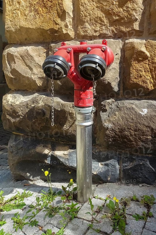 Hydrant, red faucet for extracting water, back masonry, paving stones, Tübingen, Baden-Württemberg, Germany