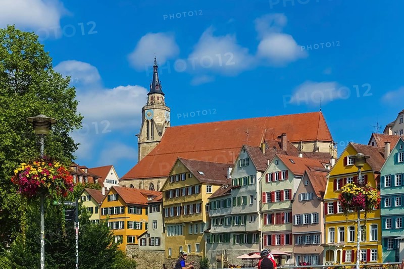 Historic old town, Neckar front, houses, colorful facades, collegiate church, people, cyclists, helmets, left floral decoration on street lamp, colorful blossoms, light, on Neckar, Tübingen, Baden-Württemberg, Germany