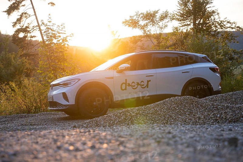 White car on gravel under the evening sun, surrounded by nature, quiet atmosphere, VW ID4 electric car, deer car sharing, Calw, Germany