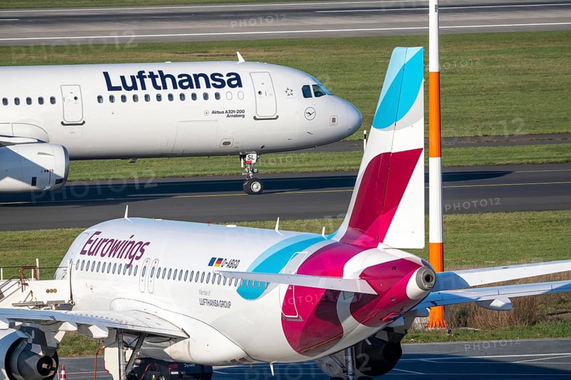 Lufthansa Airbus A321-200 on taxiway for takeoff, Eurowings Airbus parks outside position, Düsseldorf airport, DUS