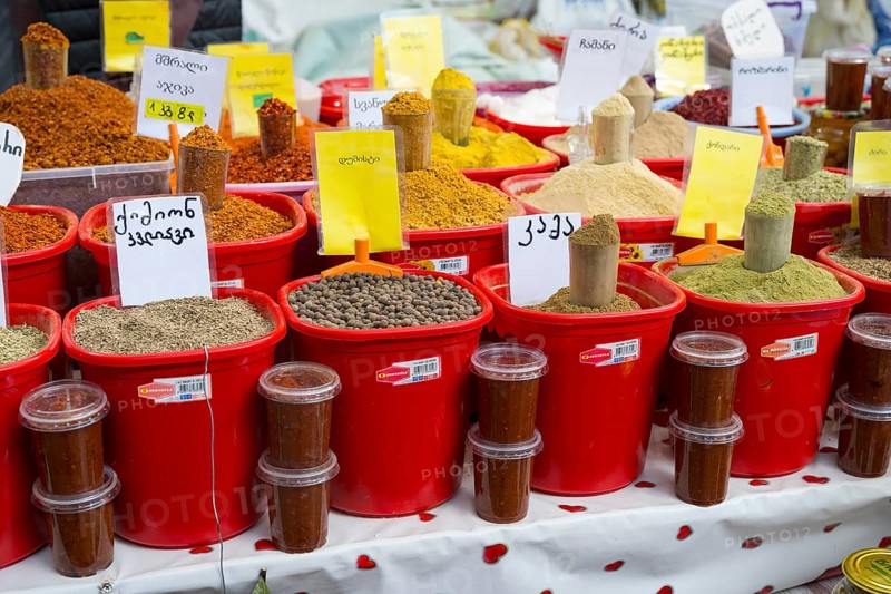 A market stall with red buckets full of colorful spices and Georgian lettering, Akhaltsikhe market, Samtskhe-Javakheti region, Samtskhe-Javakheti, Georgia