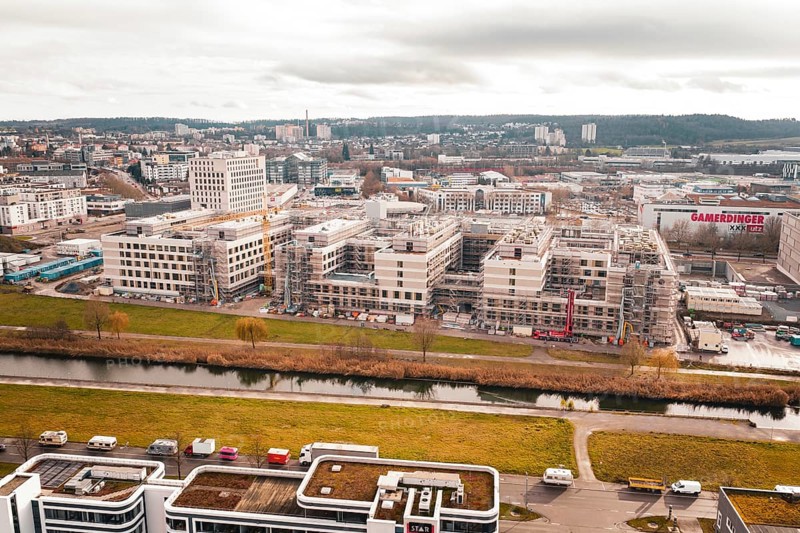 New hospital aerial view of an area with modern buildings, a river and a large construction site, Böblingen, Germany
