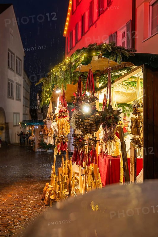 Sales stand at the Christmas market with wooden decorations and lights in the rain at night, Böblingen Christmas market, Germany