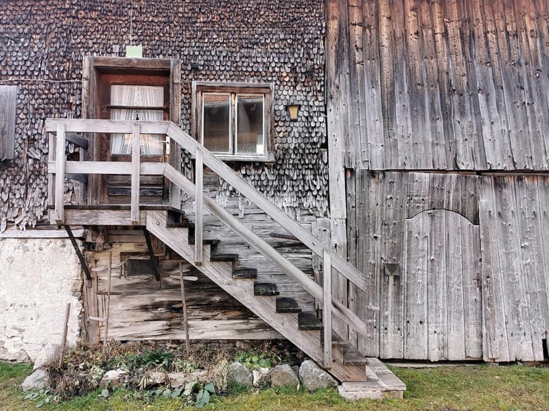 Detail of an old farmhouse in Schöllang, wooden staircase and entrance door, Illertal, Oberallgäu, Allgäu, Bavaria, Germany