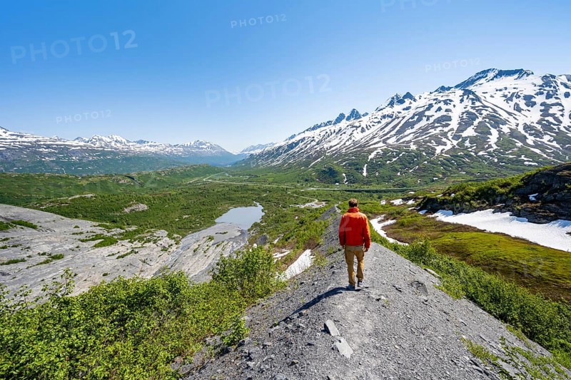 Hikers on glacial moraine, view of the vast Tsina River valley with mountains, Worthington Glacier Lagoon, Worthington Glacier State Recreational Site, Chugach Mountains, Alaska, USA
