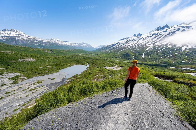 Female hiker on glacial moraine, view of the vast Tsina River valley with mountains, Worthington Glacier Lagoon, Worthington Glacier State Recreational Site, Chugach Mountains, Alaska, USA